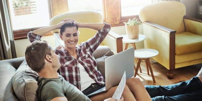 Couple on couch discussing creating wealth from their home equity.